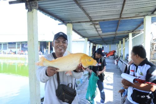 Peserta menunjukkan ikan hasil tangkapan terbesar pada kegiatan Polres Gresik Gelar Lomba Mancing dalam rangka Hari Bhayangkara ke-80.